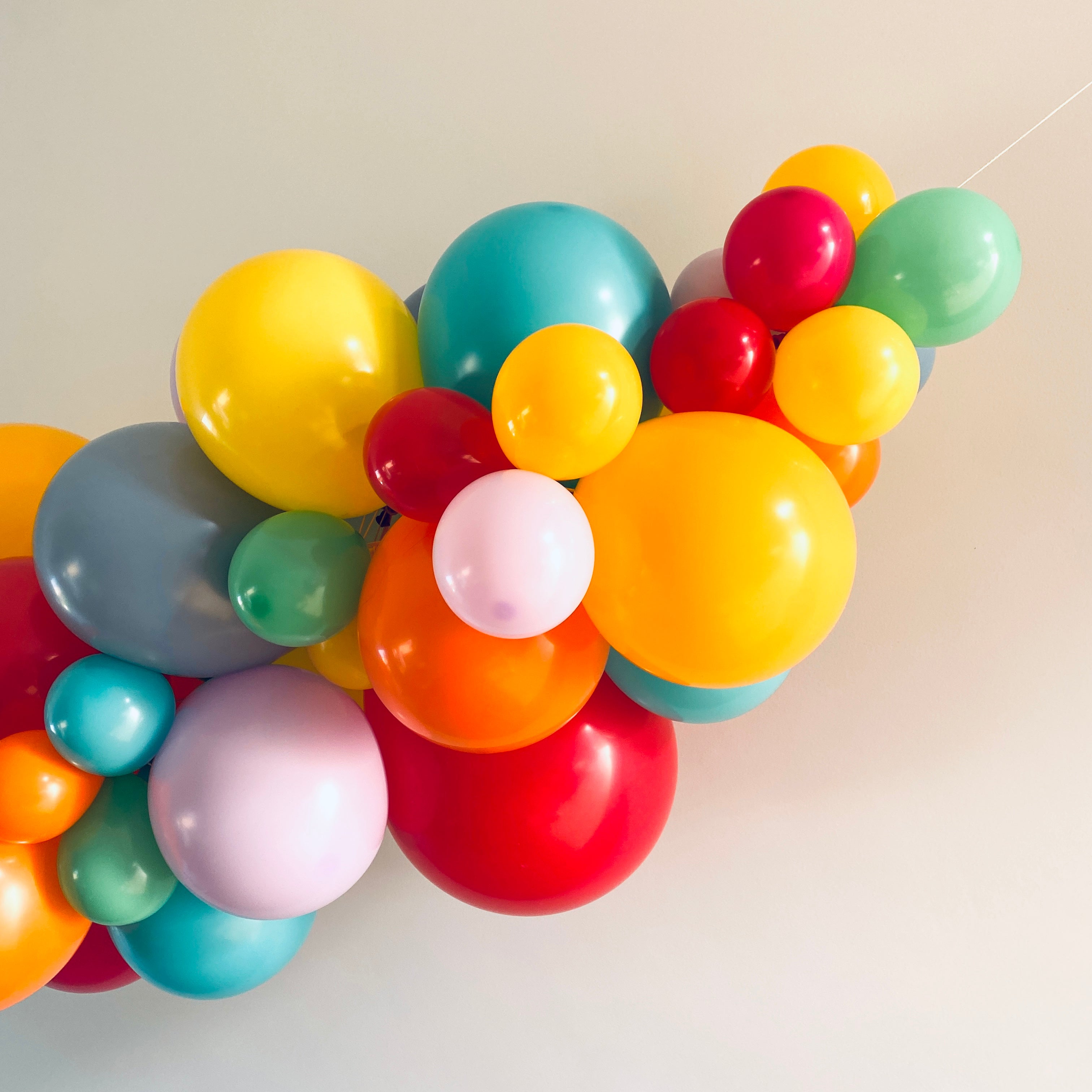 ballonslinger ballonnenboog Jesse kleurrijk feest deco decoratie geel oranje blauw aqua groen paars zacht blauw rood pastel paars pastel groen