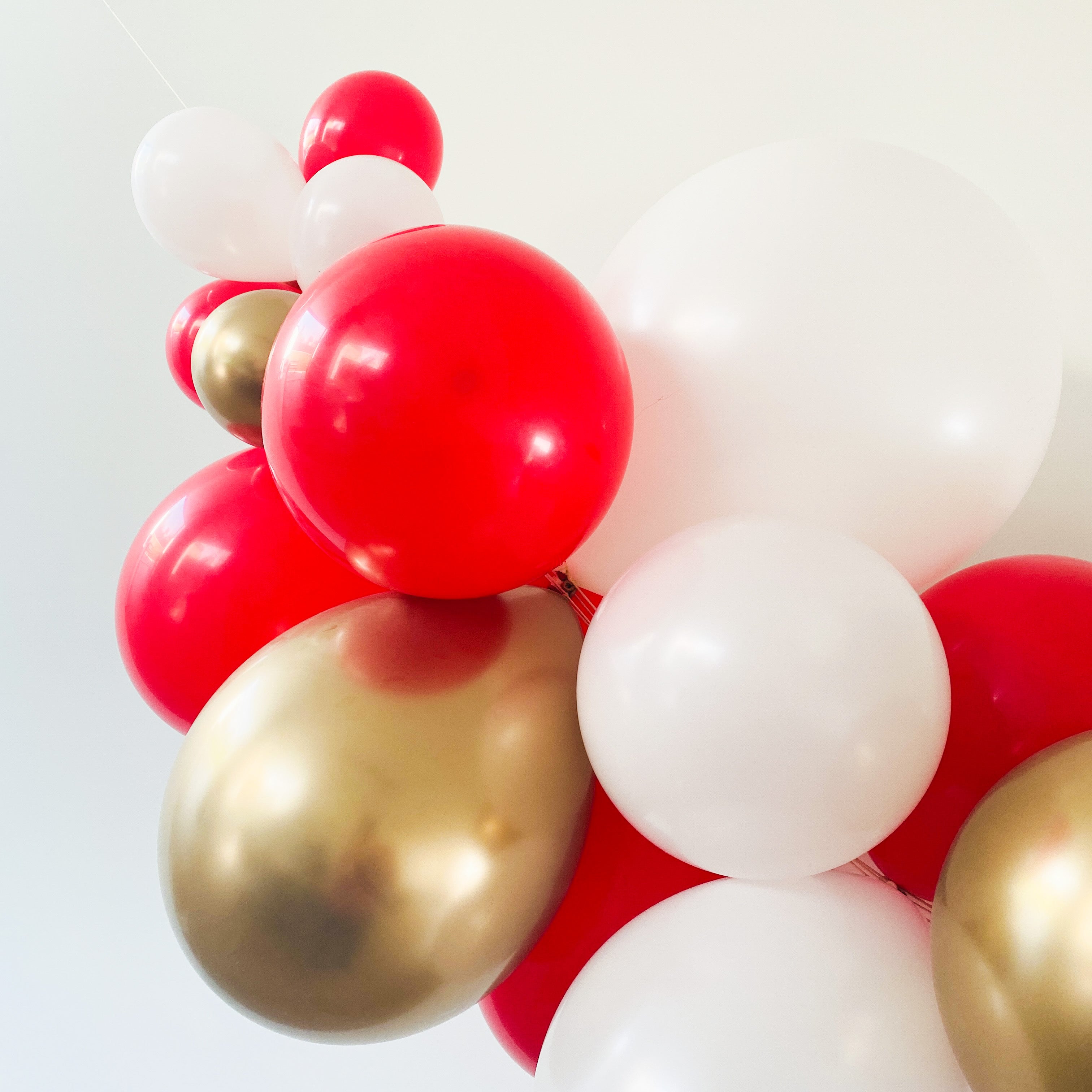 Ballonslinger ballonnenboog rood wit goud als feestdecoratie circus