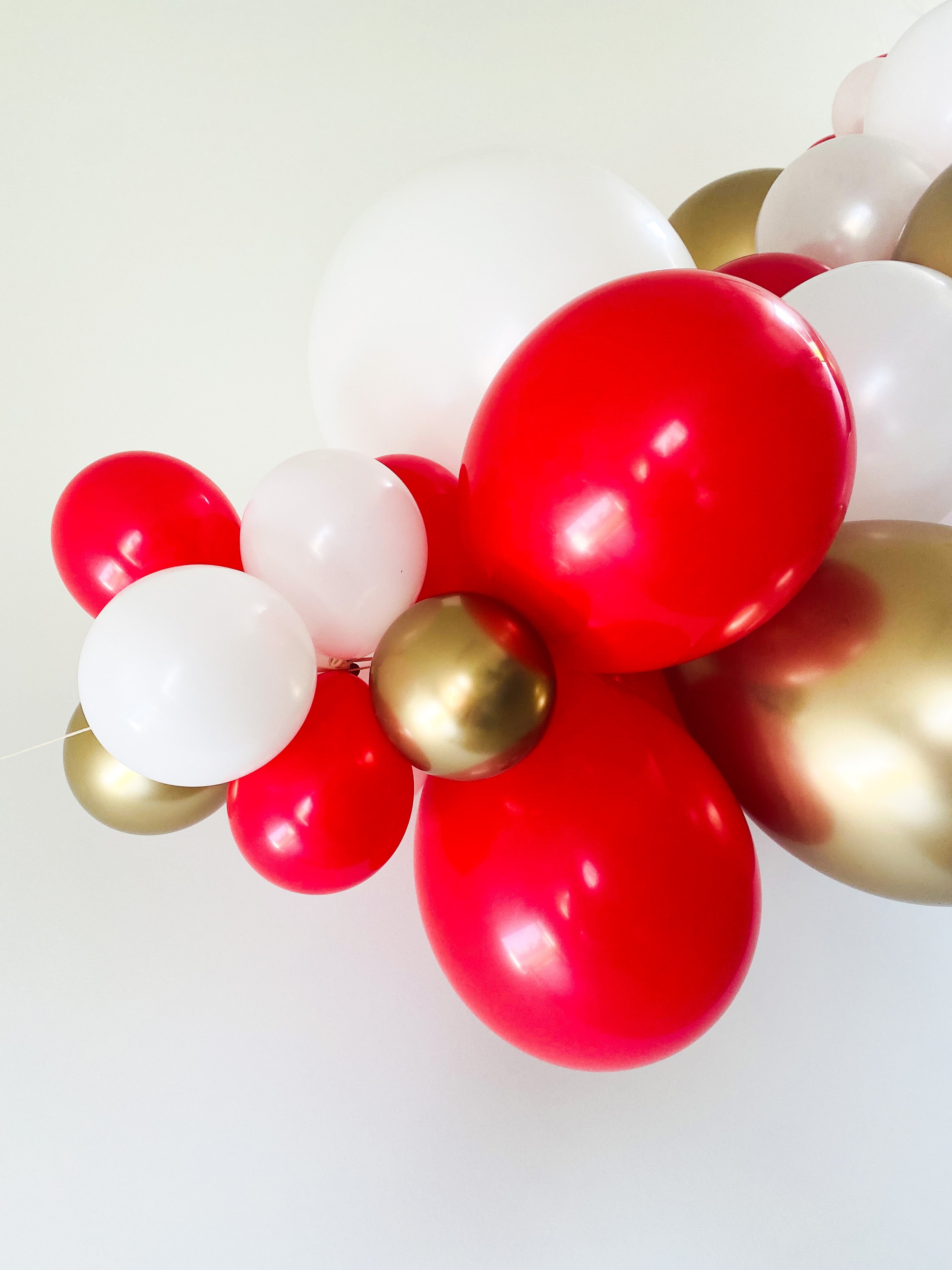 Ballonslinger ballonnenboog rood wit goud als feestdecoratie circus
